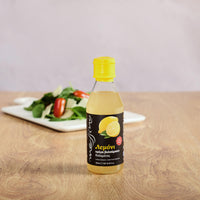 Bottle of Messino lemon balsamic glaze with plate of salad
