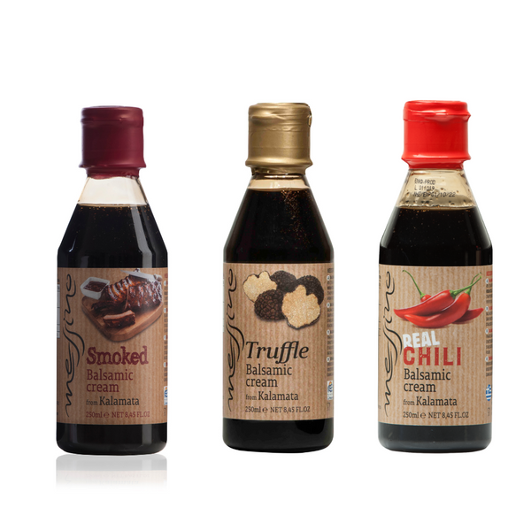 Three bottles of balsamic cream with different flavor labels on a white background