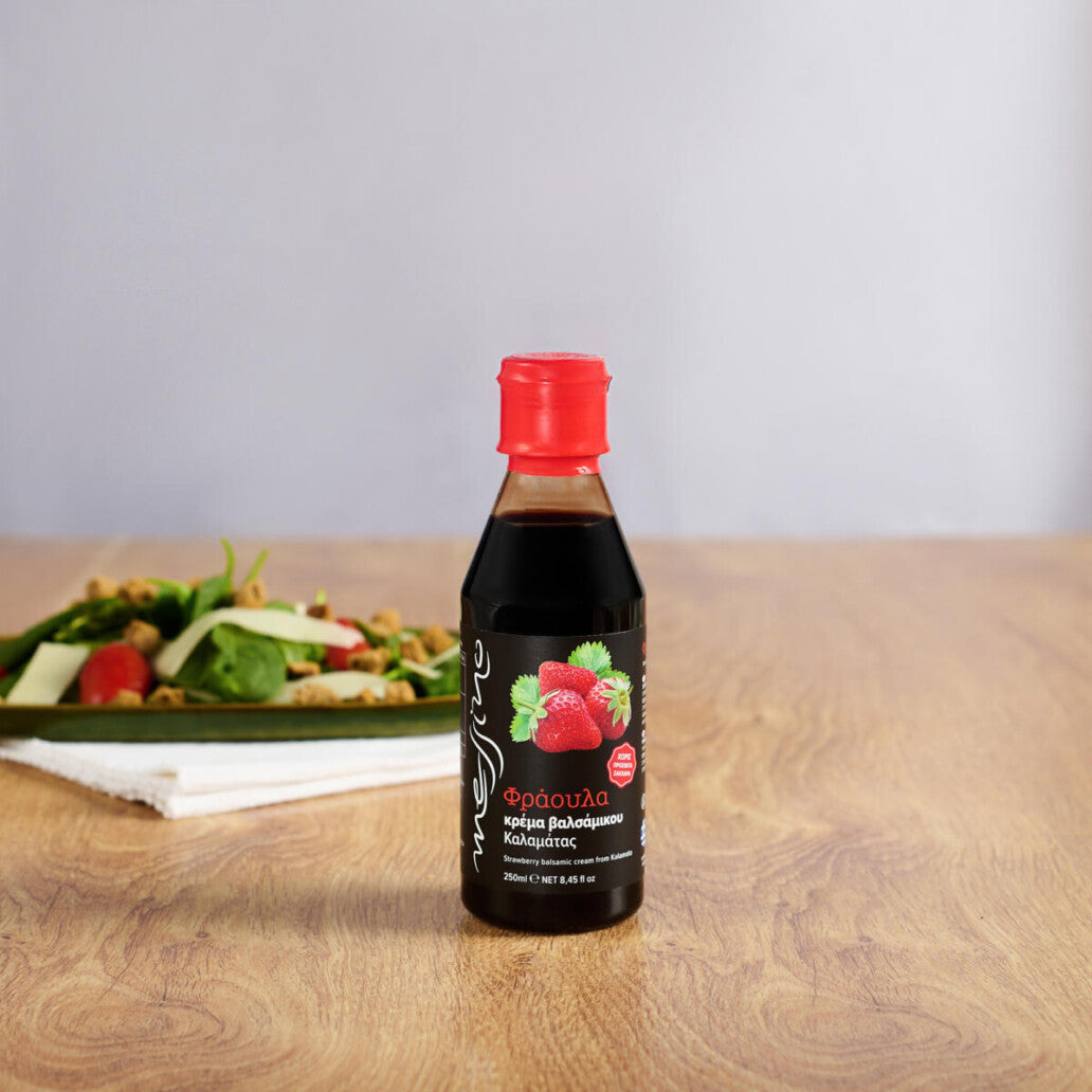Bottle of Messino Strawberry Balsamic Glaze in front of plated salad