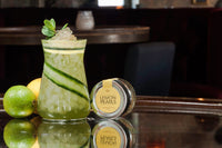 Cocktail topped with Messino Lemon Pearls next to jar