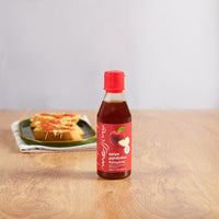 Jar of Messino Apple Cider Vinegar Glaze with plate of bruschetta in the background