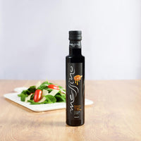 Front of bottle of Messino Balsamic Vinegar with Honey and salad in the background