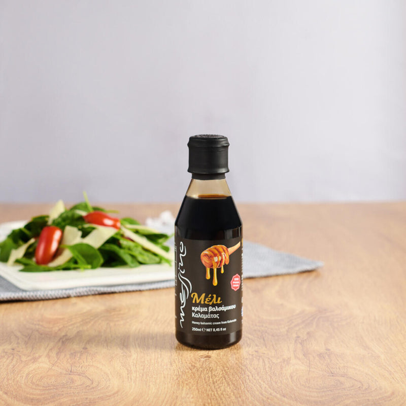 Bottle of Messino Balsamic Glaze with Honey and plated salad in the background