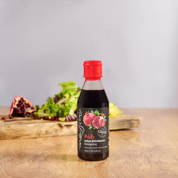 Bottle of Messino Balsamic Glaze with Pomegranate and salad in the background