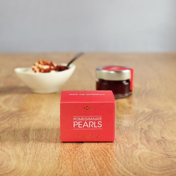 Box of Messino Pomegranate Pearls and bowl of ice cream and jar in the background