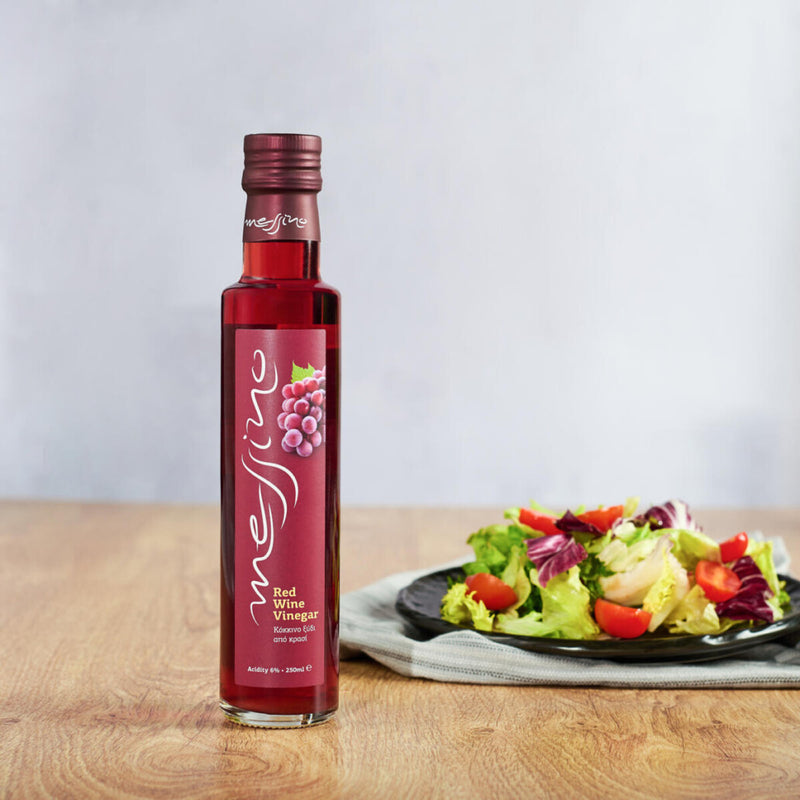 Bottle of Messino Red Wine Vinegar next to plated salad
