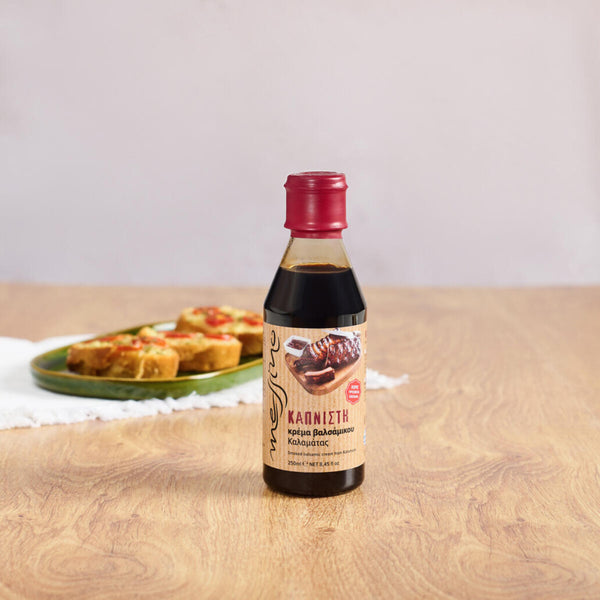 Bottle of Messino Smoked Balsamic Glaze and bruschetta in the background