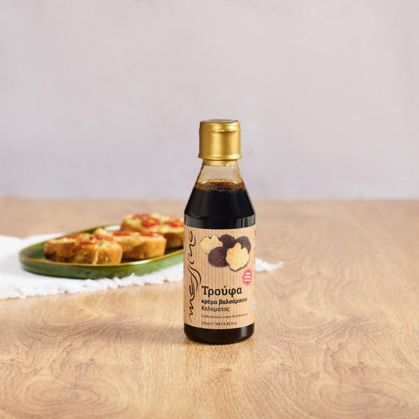 Bottle of Messino Balsamic Glaze with Truffle and plated bruschetta in the background