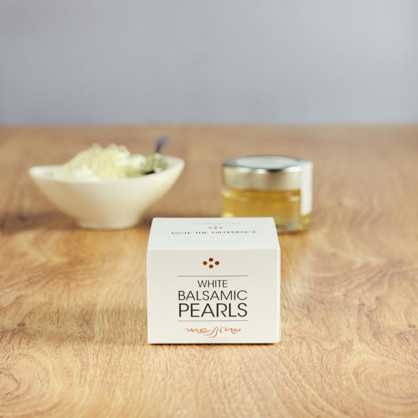 Box of Messino White Balsamic Pearls with bowl of ice cream next to jar in the background