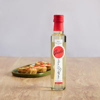 Bottle of Messino White Wine Vinegar with Garlic and bruschetta in the background