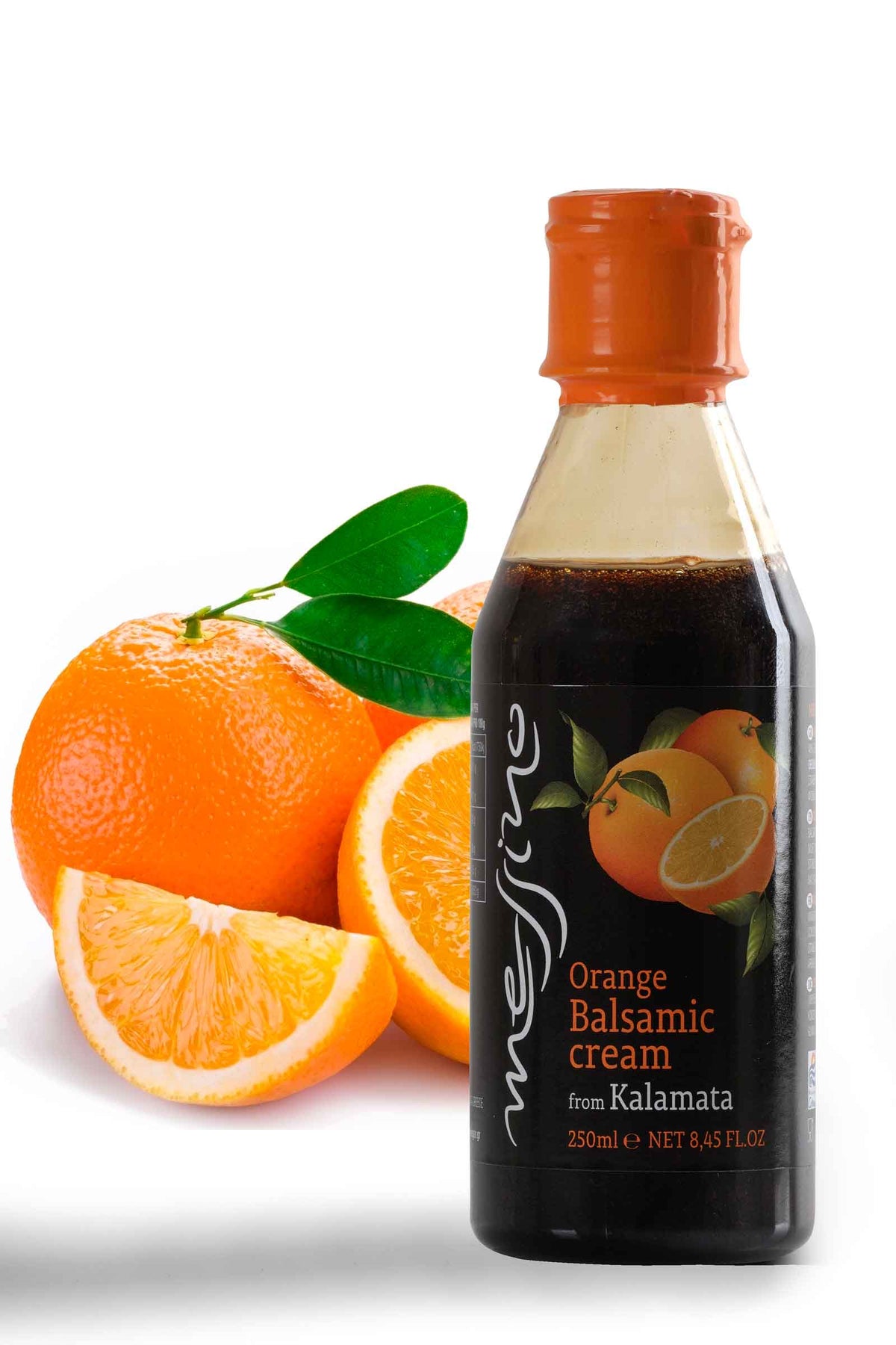 Front label of bottle of Messino Balsamic Glaze with Orange and oranges in the background