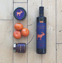 Oilladi Kalamon olive spread bottle, extra virgin olive oil bottle, forest honey jar and tomatoes
